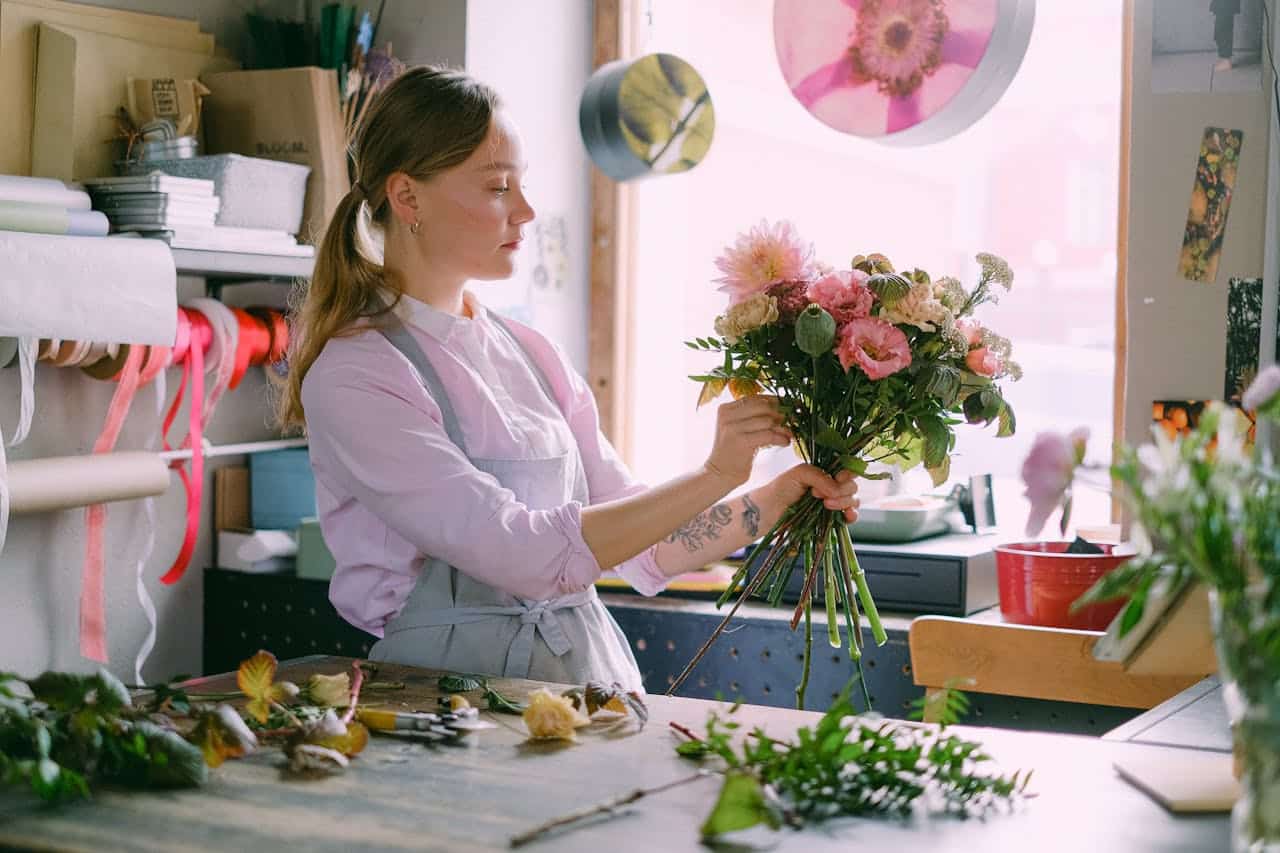 A skilled florist arranging a beautiful bouquet in a bright floral shop.